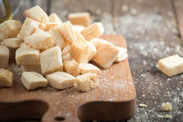 homemade croutons from white bread in wood on old wood table

