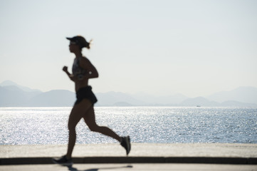 A jogger passes in defocus blur silhouette on the Copacabana boardwalk in Rio de Janeiro, Brazil