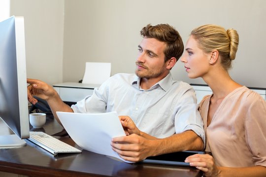 Man and woman working on computer in office