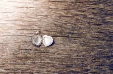 Close up of heart locket on wooden background with retro style