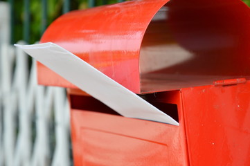 letter in red post box on home fence
