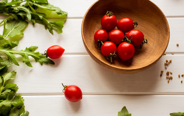 tomatoes and arugula on a white wooden table