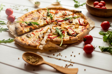 Delicious pizza with cheese and vegetables on white wooden background