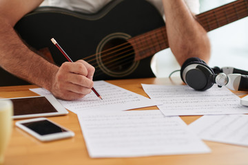 Close-up image of composer examining sheets with notes