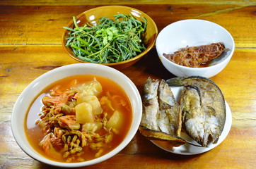 deep fried snake head fish eat couple with mixed vegetable Thai spicy and sour soup