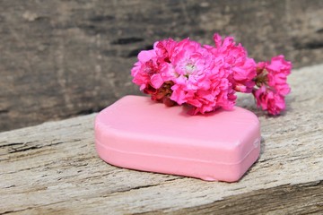 Soap and flower on wooden background 