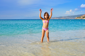 Adorable toddler girl enjoying her summer vacation at beach