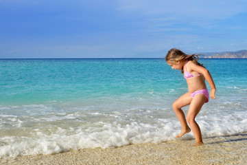 Fototapeta na wymiar Adorable toddler girl enjoying her summer vacation at beach