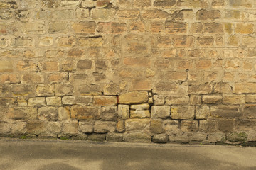 Hintergrund – Alte Mauer aus Buntsandsteinquadern und Boden aus Asphalt
Background - Old wall of...