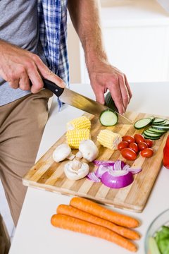 Mid-section Of Man Chopping Vegetable In Kitchen