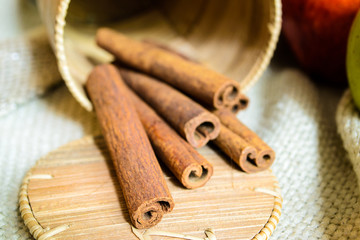 Spices cinnamon sticks on the cloth on a wooden table