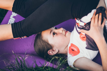 Girl meditating outdoors. Child practicing yoga
