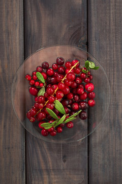 cowberries and red currants in a glass plate, vertical top view