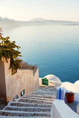 Street view in Oia, Santorini. The sea and caldera on background. Shot at sunset