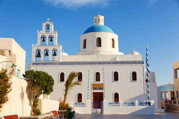 Naklejka premium Church in the town square in Oia, Santorini at at sunrise.