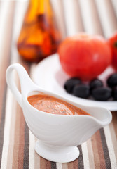 Tomato sauce with olives in a white bowl. Vertical shot.