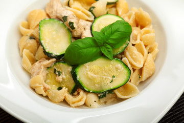 Pasta shell with chicken, zucchini, cream and basil. Horizontal shot.