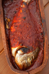 Bream fish baked in roof tile with tomato sauce.