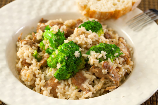 Slow cooked dish with chicken tights, rice and broccoli. Close up