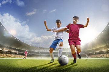 Obraz na płótnie Canvas Childrens are playing soccer on grand arena