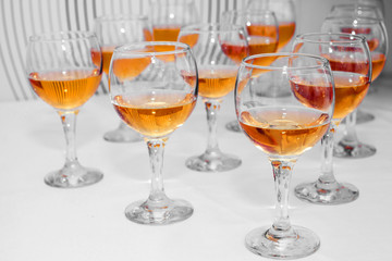 Glasses with bright wine on the table in anticipation of drinking. Festive alcohol for many people. Holiday and anniversary.