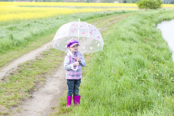 little girl with umbrella in spring nature