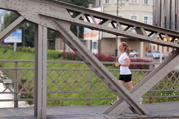 sporty woman running  on sidewalk