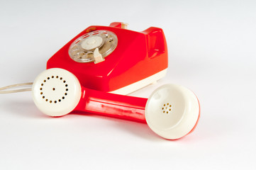 Retro orange telephone with rotary dial on white