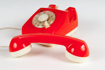 Retro orange telephone with rotary dial on white