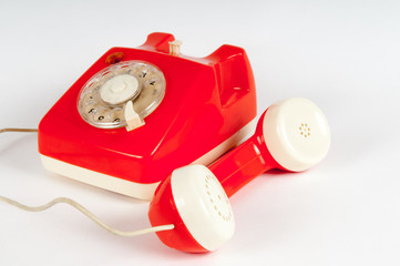 Retro orange telephone with rotary dial on white