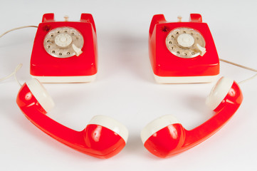 Retro orange telephone with rotary dial on white