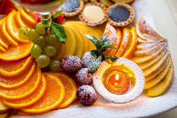 Cake with many fruits oranges, grapes, apple etc