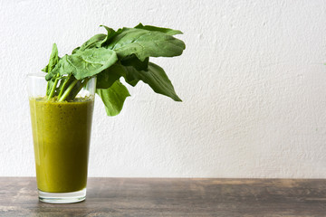 Healthy drink with spinach on wood
