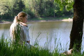 am See, junge Frau im Gras am Seeufer