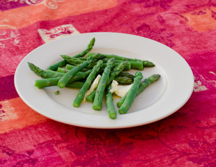 Cooked asparagus with butter on a plate
