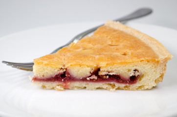 Slice of bakewell tart on plate with fork