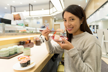 Woman having sushi in japanese restaurant