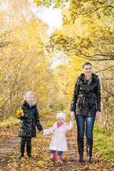 mother with her daughters in autumnal nature