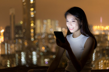 Young woman use of cellphone at night