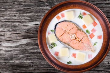 red fish soup with vegetables and dil, top view