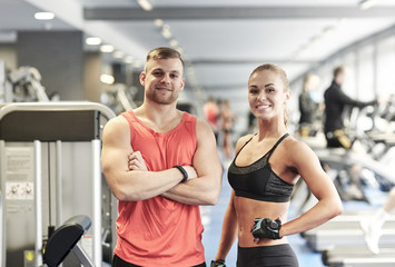 Fototapeta na wymiar smiling man and woman in gym