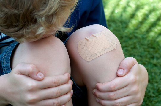 Boy with a plaster on his injured knee