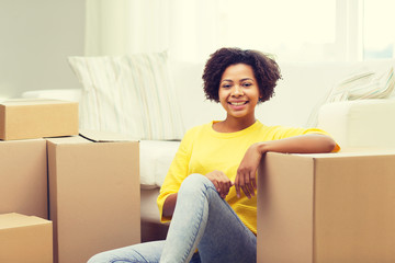 happy african woman with cardboard boxes at home