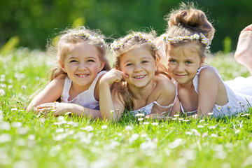 Happy girls are playing on the camomile field 