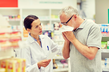 Obraz premium pharmacist and senior man with flu at pharmacy