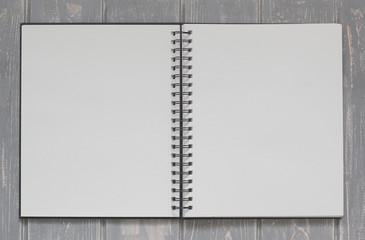Note book on grey wooden desk.
