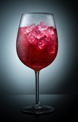 Red cold drink in a glass with ice.