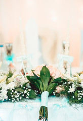 Rich bunch of pink peonies and lilac eustoma roses flowers, green leaf in glass vase.