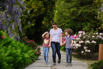 Fototapeta premium Young mother walking with her two children