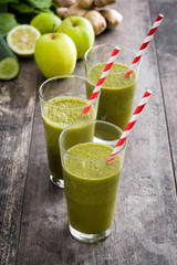 Healthy green detox with spinach, cucumber, lime and apples on a rustic wooden table
